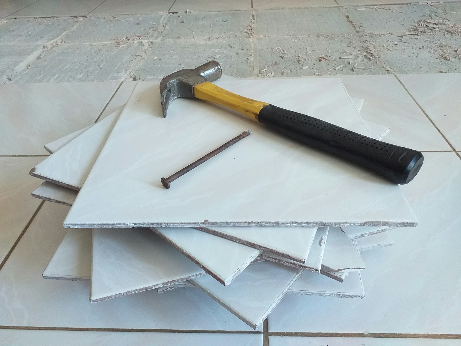 a hammer sitting on top of a pile of tile